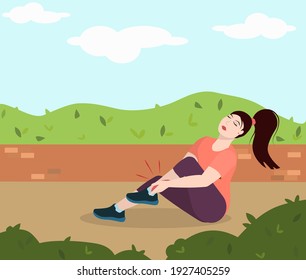 a young brunette woman sits on the ground in a park and holds on to a sore leg injured while running. The concept of a healthy lifestyle and injuries during sports