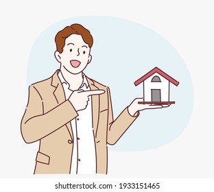 Young business man holding home model and presenting with hand and pointing with finger. Hand drawn in thin line style, vector illustrations.