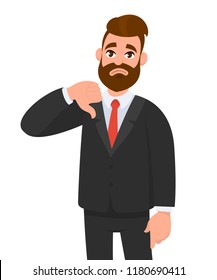 Young business man showing thumbs down sign, dislike, looks with negative expression and disapproval. Disagreement, disgust and negative expressions. 