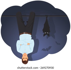 Young businessman and the bat are hanging upside down near each other
