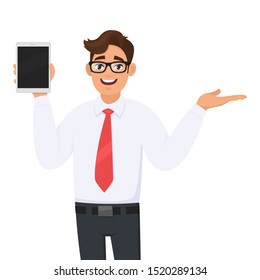Young businessman in formal wear showing a digital tablet computer & pointing/presenting hand to copy space. Person holding a latest tab device. Male character design illustration in vector cartoon.