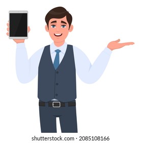 Young businessman showing tablet and presenting hand. Trendy person gesturing hand to copy space. Modern technology lifestyle. Male character introducing something. Cartoon illustration in vector.
