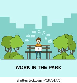 Young businessman sitting on a bench in a park and working.