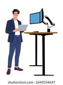 Young businessman in suit and glasses stands with digital tablet near ergonomic standing desk with dual monitors. Modern office, tech-savvy workspace, productivity concept