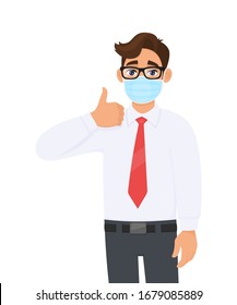 Young Businessman Wearing Face Medical Mask And Showing Thumbs Up Sign. Trendy Person Covering Surgical Mask And Gesturing Okay, OK, Success Symbol. Male Cartoon Design Illustration In Vector Style.