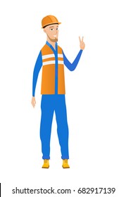 Young caucasian builder showing the victory gesture. Cheerful builder in hard hat showing the victory sign with two fingers. Vector flat design illustration isolated on white background.