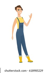 Young caucasian farmer in coveralls waving her hand. Full length of farmer waving her hand. Farmer making greeting gesture - waving hand. Vector flat design illustration isolated on white background.