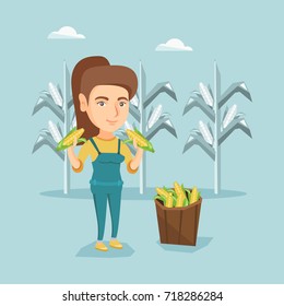 Young caucasian farmer holding corn cobs on the background of corn field. Farmer collecting corn. Happy smiling farmer standing near basket with corn. Vector cartoon illustration. Square layout.