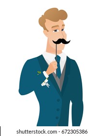 Young caucasian groom holding a fake paper moustache on a stick in front of his face. Cheerful groom with a fake mustache. Vector flat design illustration isolated on white background.