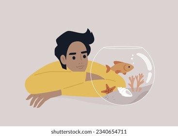 A young Caucasian person watching a goldfish swimming in a round water tank