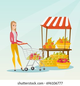 Young caucasian woman pushing a supermarket cart with some vegetables and fruits in it. Cheerful woman shopping in the store with a cart. Vector flat design illustration. Square layout.