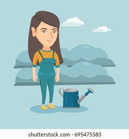 Young cheerful caucasian farmer standing near watering can on the background of agricultural field with bushes. Smiling farmer watering plants in the garden. Vector cartoon illustration. Square layout