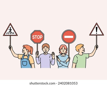 Young children hold traffic signs urging peers to follow safety rules walking streets. Happy preteen kids with street traffic signs recommend paying attention to problem of car accidents.