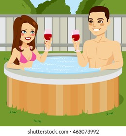 Young couple enjoying outdoor jacuzzi hot tub toasting with red wine