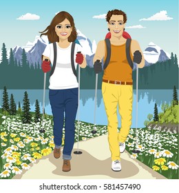 Young couple hiking outdoors with backpacks in summer mountains
