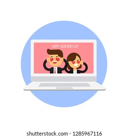 Young couple holding pink hearts over eyes against laptop and coffee mug on table, Happy Valentine's Day