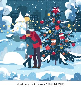 Young couple kiss, enjoying, dressed warm. Woman with a man in the evening walking under falling snow in the city park by the christmas tree. Vacation together in winter holidays.