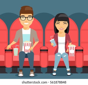 Young couple man and woman in a movie theater laugh on the film. The guy in the river holding the popcorn. Girl with soda in hand. Happy people.