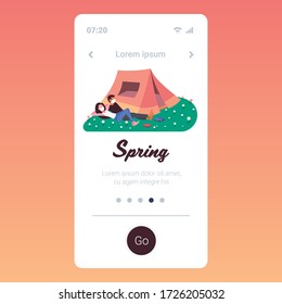 young couple in medical masks enjoying the camping coronavirus pandemic quarantine concept man woman having rest lying on grass copy space smartphne screen mobile app full length vector illustration