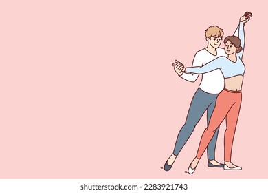 Young couple performs passionate dance semba salsa or kizomba bachata wishing to become professional dancers and perform in front of audience. Man hugging woman from behind performing salsa dance 