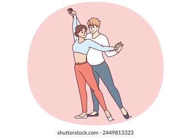 Young couple performs passionate dance semba salsa or kizomba bachata wishing to become professional dancers and perform in front of audience. Man hugging woman from behind performing salsa dance