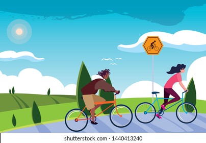 young couple riding bike in landscape with signage for cyclist