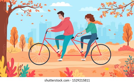 Joven pareja montando bicicleta tándem en el parque de la ciudad en otoño