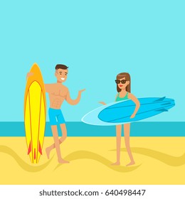 Young couple walking on the beach with surfboards