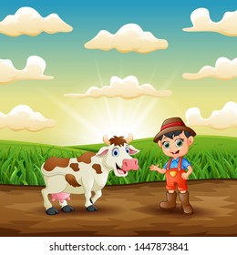 Young farmer with his cow in the field