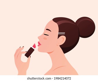 Young fashion woman with beautiful face paints her lips with scarlet lipstick