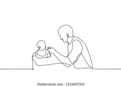 Young Father Feeding Baby Sitting In Baby Chair - One Line Drawing Vector. Concept Of Single Father Feeding Baby With Spoon, Male Nanny, Babysitter