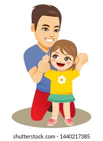 Young father holding little baby girl hands helping her learning walking