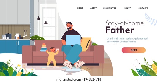 young father playing with little son and using laptop fatherhood parenting concept dad spending time with baby