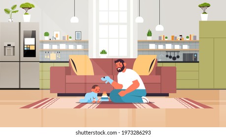 young father playing with little son at home fatherhood parenting concept dad spending time with his kid