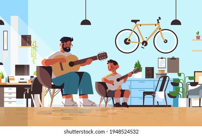 young father teaching little son to play the guitar at home parenting fatherhood concept