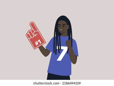 A young female African team supporter waving a foam finger, sports competition