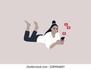 A young female Asian character lying on their stomach and checking their mobile phone notifications