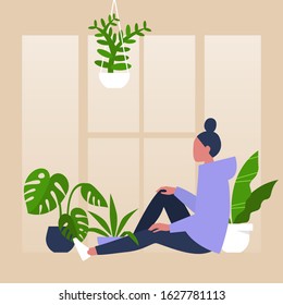 Young female character sitting by the window surrounded by house plants, meditative relaxation