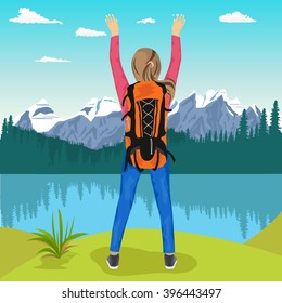 young female hiker with her hands up enjoying mountain lake
