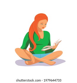 A young female with red curvy hair sits in a lotus pose and reads a book attentively