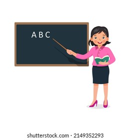 Young female teacher holding a stick pointer standing in front of class teaching on lesson at blackboard 