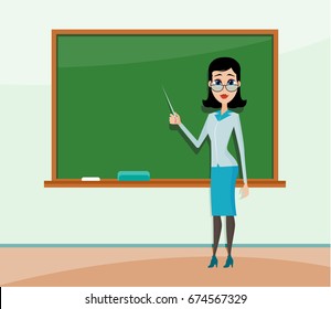 Young female teacher standing in front of blackboard. Teacher teaching student in classroom at school, college or university.