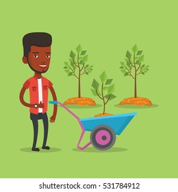 Young gardener pushing wheelbarrow with tree and dirt in the park. An african-american gardener with wheelbarrow on a background of newly planted trees. Vector flat design illustration. Square layout.