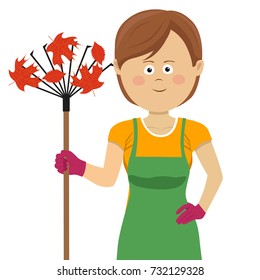 Young gardening woman standing with rake and autumn maple leaves