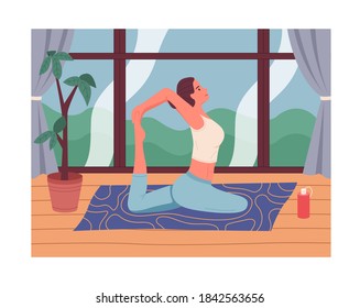 Young girl in leggings practices yoga at Karimat in front of the window, a potted plant, a bottle of water. Yoga for relaxation. Woman doing pilates during isolation. Sports and leisure at home