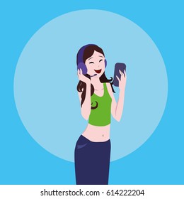 Young girl with long hair and wearing bright clothes in headphones talking on the phone. Smartphone in the hands. Green T-shirt and blue skirt. Girl manager. Receives calls. Work in the media