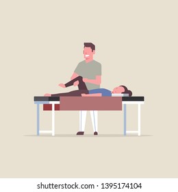 young girl lying on massage table profellional masseur therapist doing healing treatment massaging patient treating injured knee manual sport physical therapy concept full length