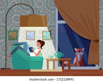 A young girl is reading a book while lounging in a cozy armchair at home. Occupation at home during isolation due to the caronovirus pandemic. The fox is looking from the street inside the house.