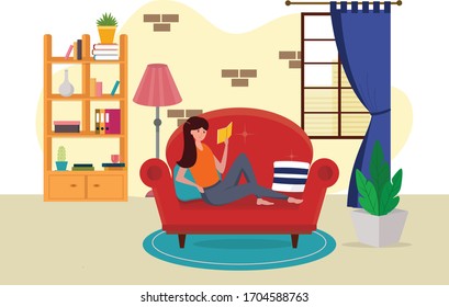 Young girl sitting on a sofa and reading a book in a home interior