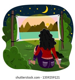 Young girl sitting in the park outdoors and watching a movie